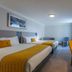 Maldron Hotel Dublin Airport guest room with twin beds, desk, chair, and round wall mirror in Dublin