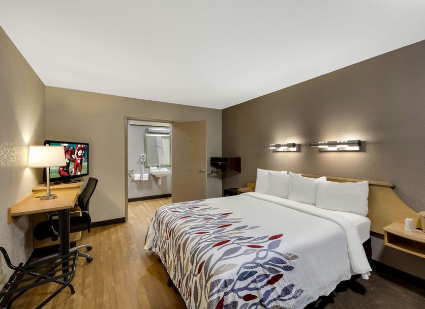 Red Roof Inn Asheville - Biltmore West room with king bed, desk, TV, and bathroom doorway