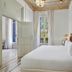 Boutique Hotel H10 Catalunya Plaza bedroom in Barcelona with ornate wood bed and tall windows