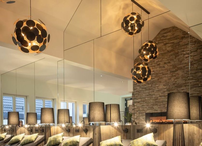 Hotel-Gasthof Höttl in Deggendorf dining area with mirrored wall, stone accent wall and pendant lighting