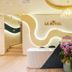 La Vela Saigon Hotel lobby with curved reception desk, chandelier and digital display in Ho Chi Minh City
