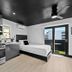 Balboa Park Hotel San Diego studio with kitchenette, bed, and balcony door