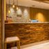 Super Hotel Okinawa Nago lobby front desk with wood-accented reception counter and warm lighting