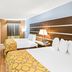 Baymont by Wyndham Forest City guest room with two beds, TV, window curtain, and bedside lamp