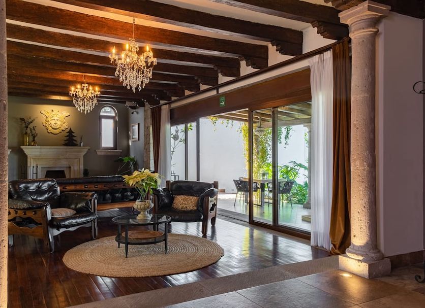 Maja Hotel Boutique in Morelia lounge with chandeliers, fireplace, wood beams and patio doors