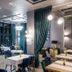 City Park Hotel Chisinau dining room with teal curtains, set tables and modern pendant lighting