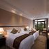 New Century Hotel Guian Guizhou in Anshun, twin beds and a balcony view of greenery