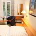 Hotel Gremersdorf - Zum Grünen Jäger guest room with twin beds, TV, seating area and balcony doors