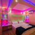 Tharangini Houseboats in Alappuzha, colorful LED-lit bedroom with double bed and red chair