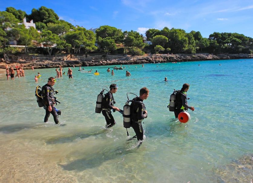 Aparthotel Niu d´Aus in Cala d'Or near a clear beach with scuba divers entering the water
