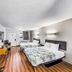 Motel 6 Moultrie, GA room with two beds, desk, wall TV and wood-look floors