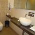 Hotel Airport Centre Point Nagpur bathroom with vessel sink, toilet, mirror and patterned wall