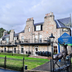 Loch Kinord Hotel in Aboyne, stone hotel exterior with lawn, fence and deer statue