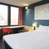 Ibis Liège Centre Opéra guest room with bed, desk, chair, and large window in Liège