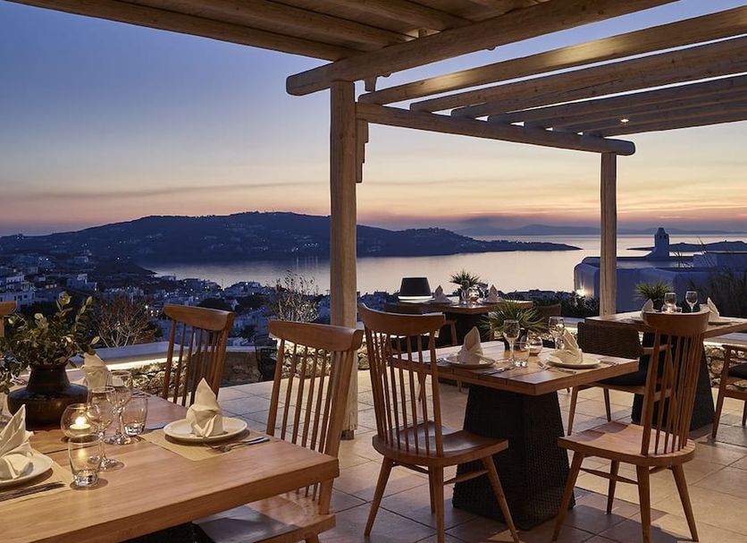 Vencia Boutique Hotel Mykonos terrace dining with sunset sea view and wooden pergola