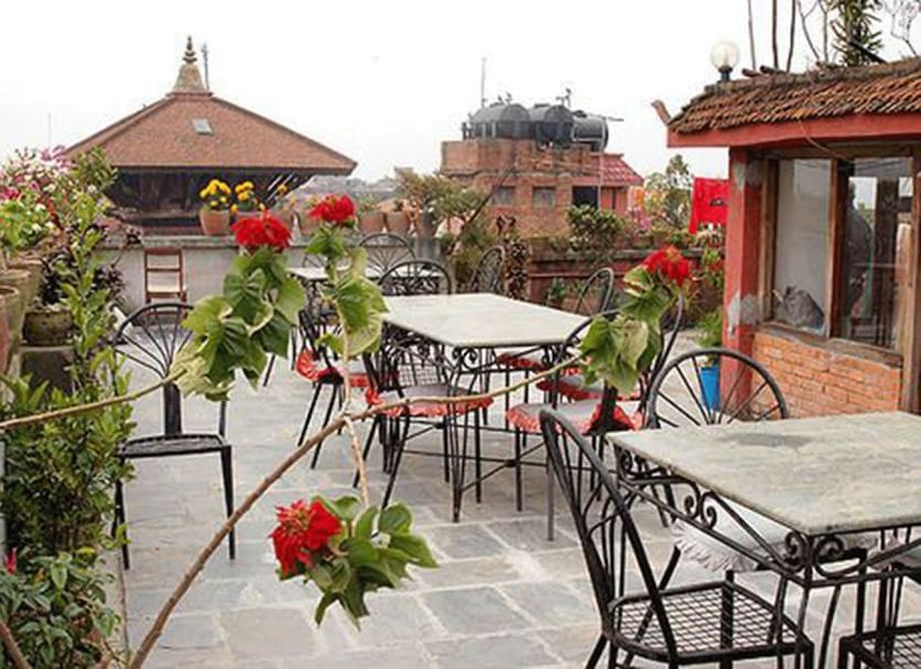 Golden Gate Guest House rooftop terrace in Bhaktapur with tables, chairs, and city views