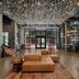 The Gordon Hotel Eugene lobby with leather seating, hanging glass ceiling art, and bar area