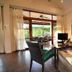 Sai Naam Lanta Residence in Ko Lanta living area with wicker seating, TV, and patio doors to greenery
