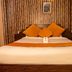 OYO 11457 Kathmandu Resort Hotel bedroom with bed, orange pillows and striped wall in Kathmandu
