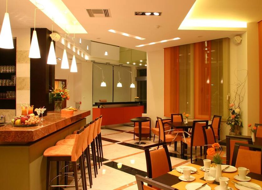 Alexandros Boutique Hotel, Náfplio: warm hotel lounge with bar, high stools, and dining tables