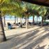 Hotel Marbella Playa Larga in Ixtapa beachside palapa with loungers and palm trees by the shore