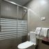 Hostal Mellizo in Lebrija bathroom with glass shower, toilet, sink and wall mirror