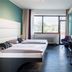 Best Western Hotel Würzburg Sued guest room with twin beds, desk, wall TV and large window in Würzburg