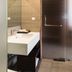 Triple E Hotel Fine Art Museum bathroom with wall-mounted sink and frosted glass shower door in Ho Chi Minh City