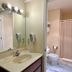 Sea Girt Lodge bathroom with vanity sink, mirror lights, toilet, and shower curtain in Sea Girt