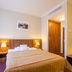 Clarion Hotel Prague Old Town bedroom with double bed, wood headboard, bedside lamps, and city-view window
