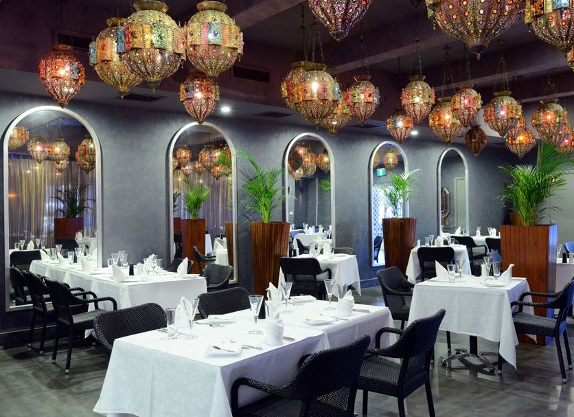 Rydges Armidale restaurant with white tablecloth dining tables and hanging lanterns in Armidale