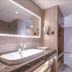 Binhai Jianguo Hotel Tianjin bathroom with lit mirror, vessel sink, vanity and walk-in shower