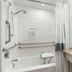 City Express by Marriott Bemidji bathroom with tub, grab bars, shower, and sink