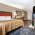 Spark By Hilton Evansville Downtown room with bed, desk, wall-mounted TV and seating area in Evansville