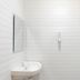 Wisma Rimadi Guest House Jakarta bathroom with sink, mirror, and handheld shower