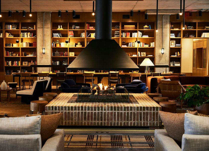 The Junto in Columbus lounge with fireplace, tall bookshelves and warm seating area