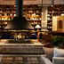 The Junto in Columbus lounge with fireplace, tall bookshelves and warm seating area