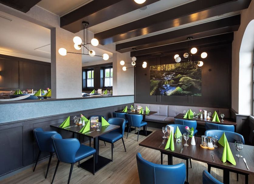 Michel Hotel Waldkirchen am Badepark restaurant with blue chairs and tables in Waldkirchen