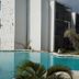 Aqua Resort in Diani Beach with a turquoise pool beside modern white buildings and palm trees