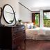 Naramata Inn guest room with queen bed, dresser, and garden view through French doors in Naramata