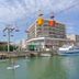 Hotel Amerique in Palavas-les-Flots with canal paddleboarders, boats and a cable car overhead