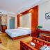 Wassim Hotel Baotou Exhibition Center room with queen bed, wood accents and seating area in Baotou