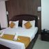 Hotel Meena Paradise, Visakhapatnam guest room with double bed, bedside tables, and wall-mounted AC