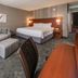 Courtyard by Marriott Fairfax Fair Oaks guest room with king bed, sofa, ottoman and desk in Fairfax