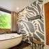 Velinn Pousada Canoa Ilhabela in Ilhabela with soaking tub beside large window and tropical view