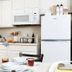 Intown Suites Extended Stay Newport News VA kitchen with white cabinets, fridge, microwave, and dining table