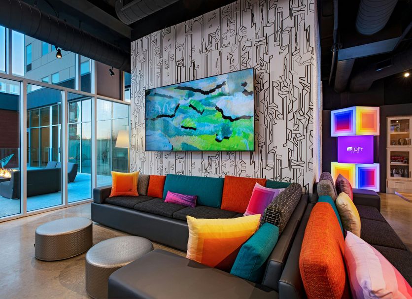 Aloft Waco Downtown lobby with colorful seating, pool view, and floor-to-ceiling windows in Waco