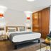 Appart'City Confort Lille Grand Palais room with bed, wardrobe, armchair and table in Lille