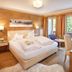 Familienhotel Hinteregger room in Rennweg am Katschberg with wood walls, balcony view and twin bed
