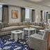 Four Seasons Hotel New Orleans suite with city views, sectional sofa, dining table and blue patterned rug